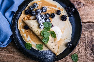Vegetarian breakfast with crepes, fresh blackberries and sour cream