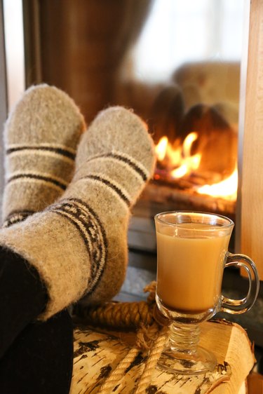 Feet in wool socks warming at the fireplace