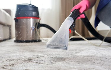 Human Cleaning Carpet In The Living Room Using Vacuum Cleaner At Home