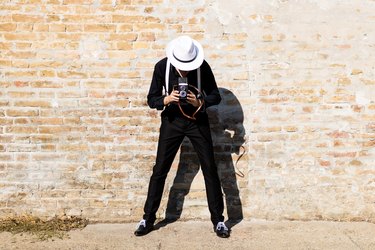 Unrecognizable Fedora Man Photographing With Vintage Medium Format Photo Camera.