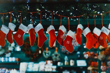 Hanging Advent calendar in form of hanging red stockings. Christmas decoration. Traditional festive decor on the blured background.