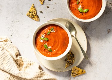 Tasty and creamy tomato soup made with fresh tomatoes and basil. Copy space.