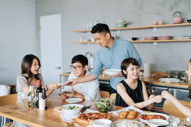 A young group of friends celebrating a newlywed's housewarming party with food and drinks