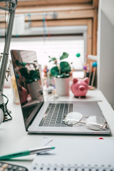 Cropped shot of technology and a notebook on a desk in an empty home office during the day