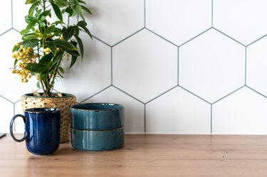 Mug and decor standing on wooden countertop in kitchen