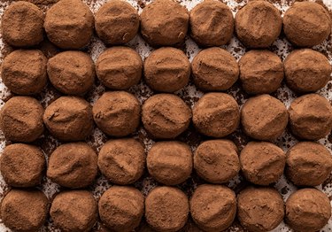 Rows of gourmet dark chocolate truffles covered with cocoa powder