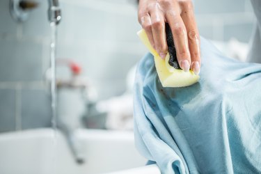 Woman Cleaning Stained Clothing With Cleaning Sponge