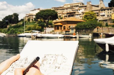 Woman drawing a hilltown of Bolsena in Italy