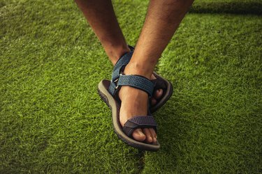 the man feet wearing sport sandals. selective focus