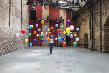 Woman in warehouse with colourful balloons