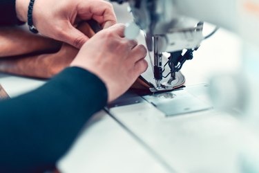 Female Sewer Stitching Up Leather Cloth With Expertise