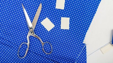 Sewing scissors on a piece of blue polkadot fabric.
