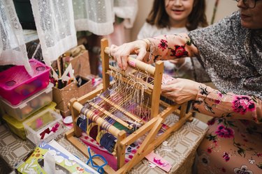 Mother and daughter using loom