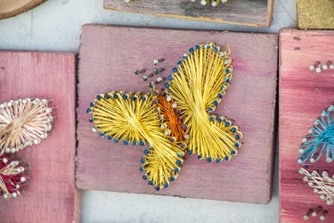 Closeup shot of a handcrafted figure with the shape of a butterfly on a wooden surface