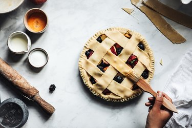 Woman brushing a typical fruit lattice pie