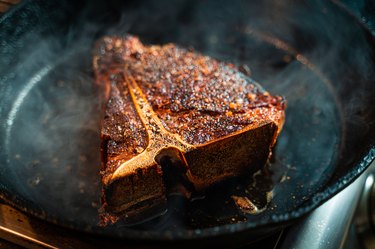 Steak frying on cast iron pan