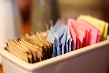 Sugar and sweetener packets in container