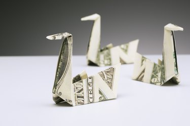 Origami swans made of dollar bills on counter