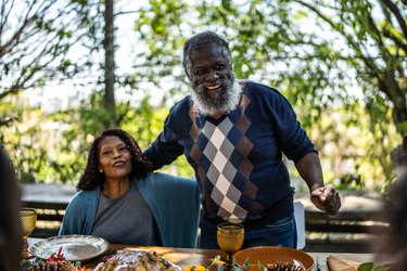 Senior man saying grace before Thanksgiving lunch at home