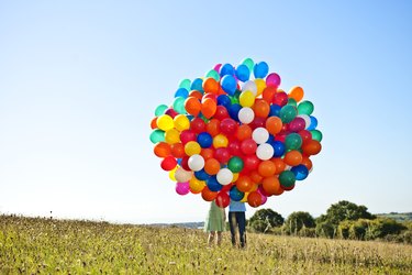 couple holding big bunch of balloons