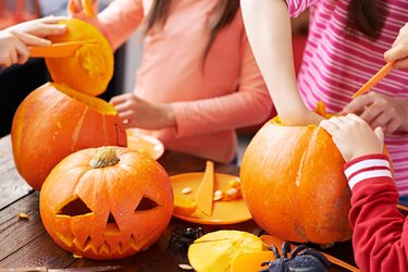 Children making Halloween pumpkin decoration for people
