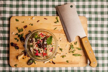 Directly Above View Of Rice And Vegetables In Bowl By Meat Cleaver On Cutting Board