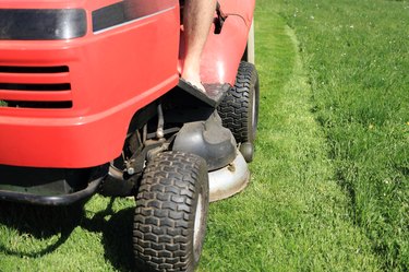 Red riding lawn mower (lawnmower, ride-on mower) in garden.