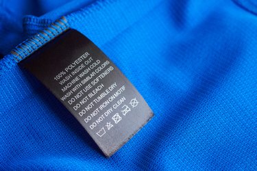 Black laundry care washing instructions clothes label on blue jersey polyester sport shirt