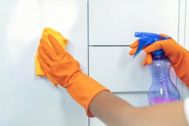 Cropped Hand Of Woman Cleaning Tiled Wall