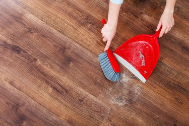 Using dustpan and brush on hardwood floor