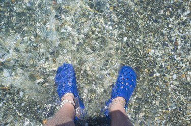 Male wearing blue clogs beside the beach