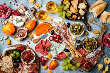 Appetizers table with wine and antipasti, including traditional Spanish tapas set on gray background