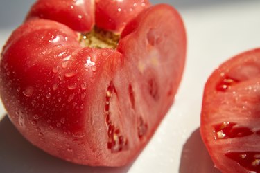 a large fresh cut tomato on an insulating white background