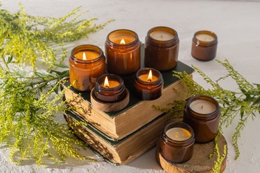 A set of different aroma candles in brown glass jars. Scented handmade candle. Soy candles are burning in a jar. Aromatherapy and relax in spa and home. Still life. Fire in brown jar