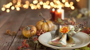 Autumn Thanksgiving dining table place setting on an old wood rustic table