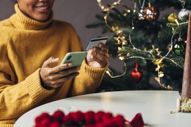 Buying Christmas Presents: a Happy Woman Making Online Orders Through a Mobile App