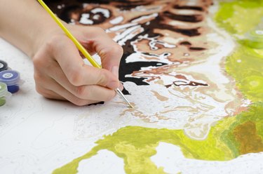 Woman's hand holding a brush for drawing close-up