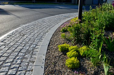 roundabout with a spotted perennial plantation that blooms and attracts insects. resembles a meadow. The center of the circle is formed by boulders and pebbles as a dry riverbed.