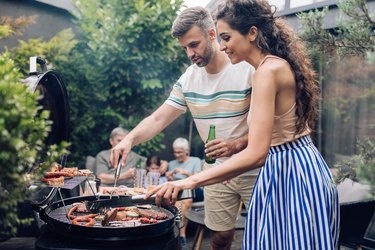 Man and woman organizing Sunday family lunch with the barbecue