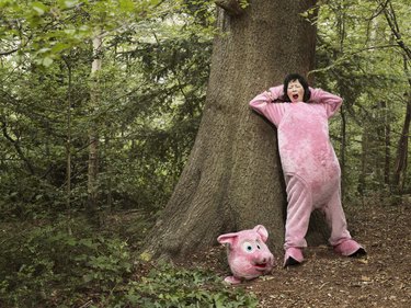 WOMAN DRESSED AS PIG IN FOREST