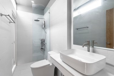 White Modern and Wood Bathroom with Shower Cabin Glass and Big mirror in Apartment