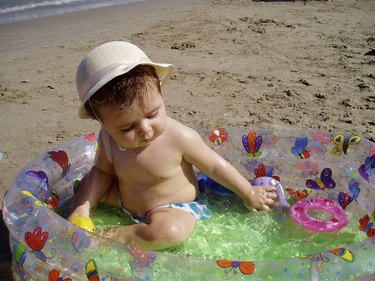 Baby girl playing in pool on beach