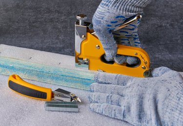 Worker performs work with a furniture stepper, shallow depth of field, close up