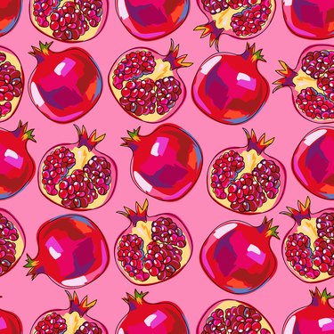 Seamless pattern with pomegranate fruits. Bright colorful fruits on a pink background. A whole pomegranate and half a fruit. Hand drawn in sketch style with black outline.