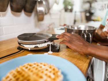 Hands of Mother  making waffles