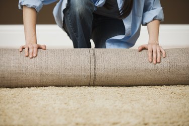 Woman unrolling carpet