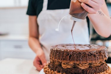 Using a squeeze bottle to frost chocolate cake