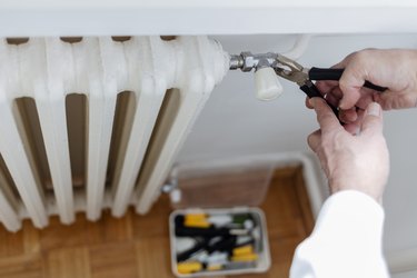 Fixing radiator with wrench.