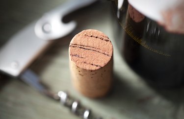 Cork with corkscrew and bottle of red wine