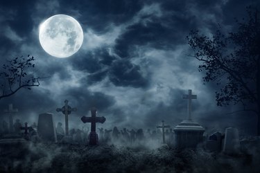Zombie Rising Out Of A Graveyard cemetery In Spooky dark Night